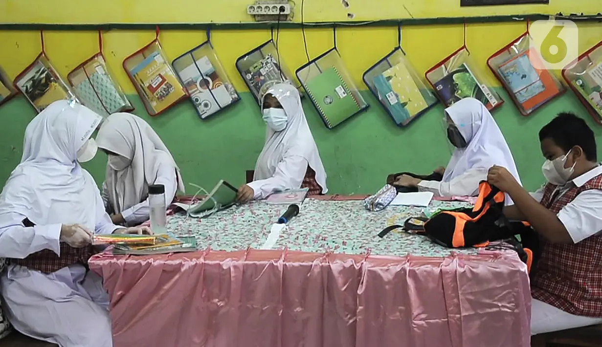 Para murid mengikuti pembelajaran tatap muka (PTM) terbatas di SDN Pisangan Baru 05 Pagi, Jakarta, Senin (8/11/2021). Orangtua dan guru diwajibkan disiplin mengedukasi protokol kesehatan secara lisan maupun melalui media sosial. (merdeka com/Iqbal S. Nugroho)