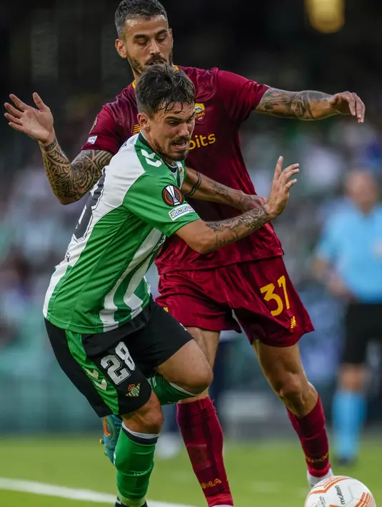 Bek AS Roma Leonardo Spinazzola berebut bola dengan gelandang Real Betis  Rodri pada laga pekan ke-4 Grup C Liga Europa 2022/2023  di Estadio Benito Villamarin, Kamis (13/10/2022).  AS Roma harus puas mendapat hasil imbang saat bertemu wakil Spanyol. (AP Photo/Jose Breton)