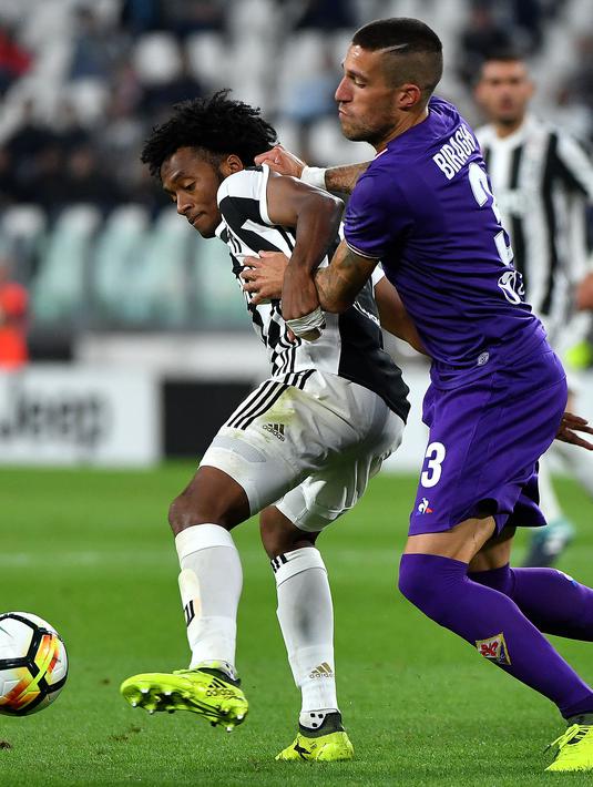 Pemain Juventus, Juan Cuadrado (kiri)  berusaha melewati adangan pemain Fiorentina, Cristiano Biraghi pada lanjutan Serie A di Allianz Stadium, Turin, (20/9/2017). Juventus menang 1-0. (AFP/Alberto Pizzoli)