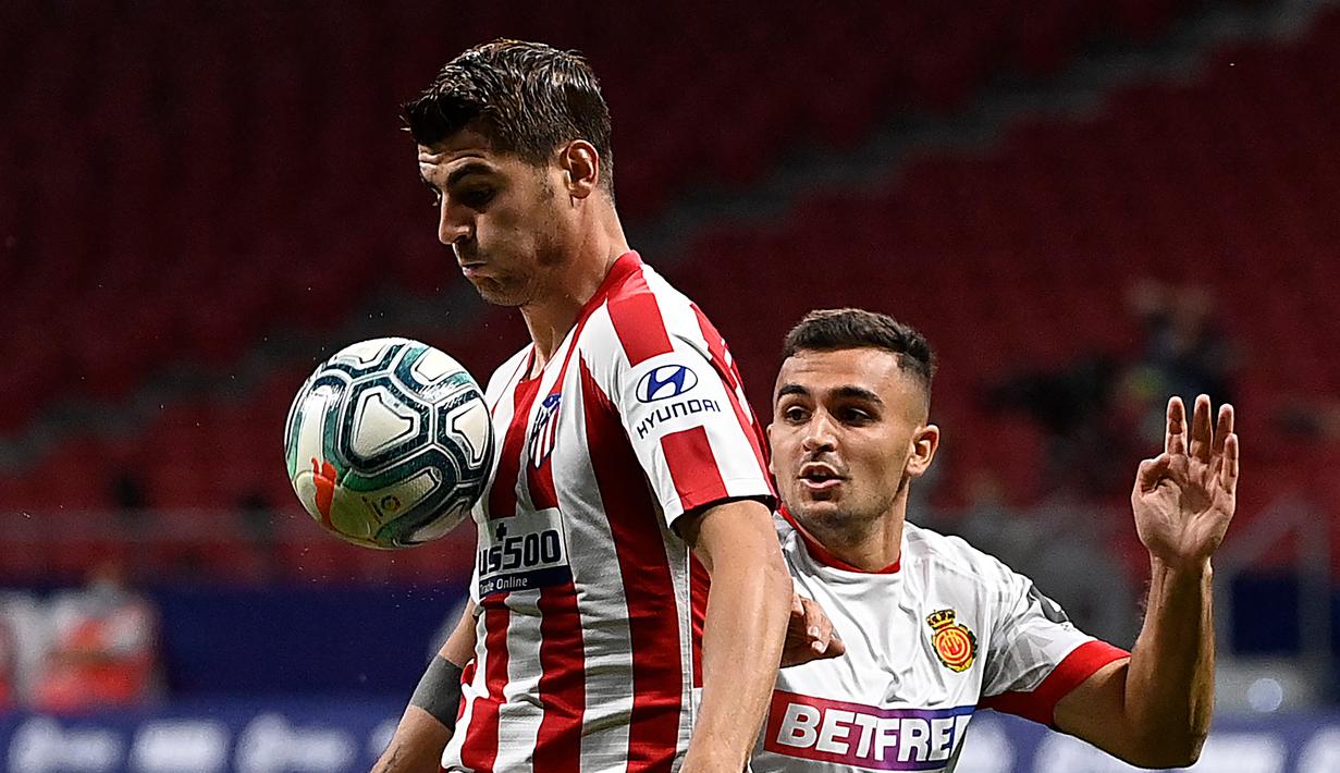 Penyerang Atletico Madrid, Alvaro Morata, berebut bola dengan bek Real Mallorca, Aleksandar Sedlar, pada laga lanjutan La Liga di Wanda Metropolitano, Sabtu (4/7/2020) dini hari WIB. Atletico Madrid menang 3-0 atas Mallorca. (AFP/Pierre-Philippe Marcou)