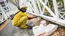 Pekerja Dinas Bina Marga DKI melakukan pengecatan ulang di sejumlah bagian dari Jembatan Penyeberangan Orang (JPO) di kawasan Thamrin, Jakarta, Kamis (28/1/2021). Pengecatan ulang itu sebagai bagian dari perawatan JPO di Jakarta guna memberikan kesan bersih dan indah. (Liputan6.com/Faizal Fanani)