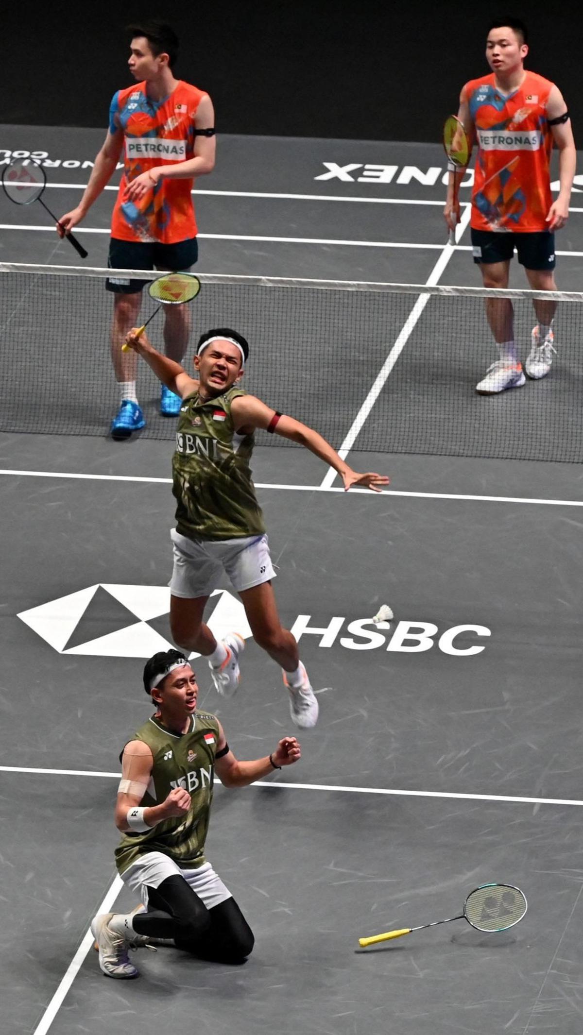 Fajar/Rian berhasil mengalahkan pasangan Malaysia, Aaron Chia/Soh Wooi Yik, dengan skor 21-16, 21-16. Foto: JUSTIN TALLIS / AFP<br>