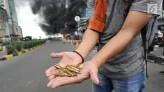 Seorang warga menunjukkan peluru dari kendaraan Polisi yang terbakar di Jalan Brigjen Katamso, Slipi, Jakarta, Rabu (22/5/2019). Belum diketahui penyebab terbakarnya dua bus yang terparkir bersama bus polisi lainnya dilokasi tersebut. (merdeka.com/Arie Basuki)