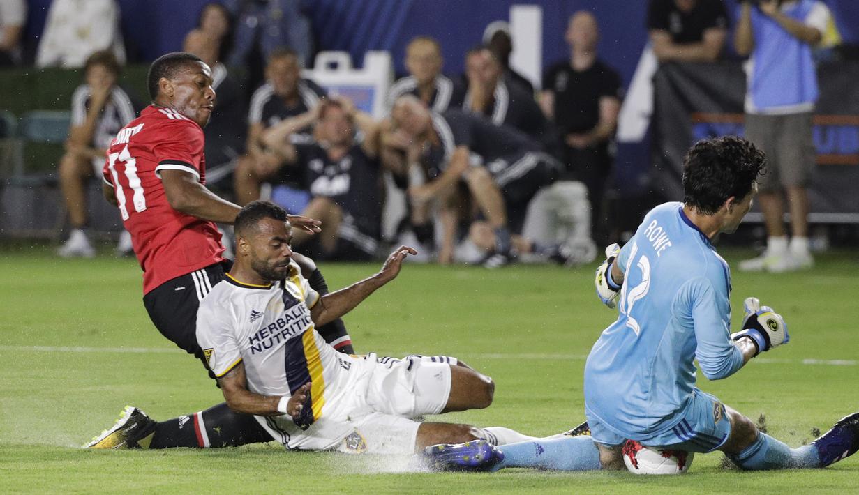Kiper LA Galaxy, Brian Rowe (kanan) menghentikan bola sepakan pemain Manchester United, Anthony Martial pada laga persahabatan di StubHub Center, California, Sabtu (15/7/2017). MU menang 5-2. (AP/Jae C. Hong)