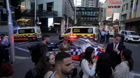 Orang-orang berkerumun di luar Westfield Shopping Centre atau Westfield Bondi Junction di timur Sydney, Australia setelah insiden penikaman. (AFP/Rick Rycroft)