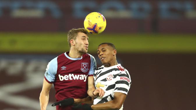 Penyerang Manchester United, Anthony Martial berebut bola udara dengan gelandang West Ham, Tomas Soucek pada pertandingan lanjutan Liga Inggris di stadion London di London, Inggris, Minggu (6/12/2020). MU menang 3-1 atas West Ham. (Julian Finney/Pool Via AP)