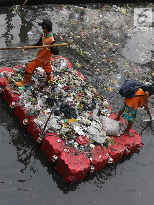 Petugas UPK Badan Air Dinas Lingkungan Hidup DKI Jakarta mengangkut ceceran sampah di Kali Cideng, Jakarta, Jumat (9/11). Pembersihan untuk mencegah terjadinya penumpukan sampah saat musim hujan di Jakarta. (Liputan6.com/Helmi Fithriansyah)