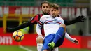 Pemain AC Milan, Ricardo Rodriguez berebut bola dengan pemain Sampdoria, Dawid Kownacki dalam lanjutan pertandingan Serie A di San Siro, Minggu (18/2). AC Milan menundukkan tamunya Sampdoria dengan skor tipis 1-0. (AP/Antonio Calanni)