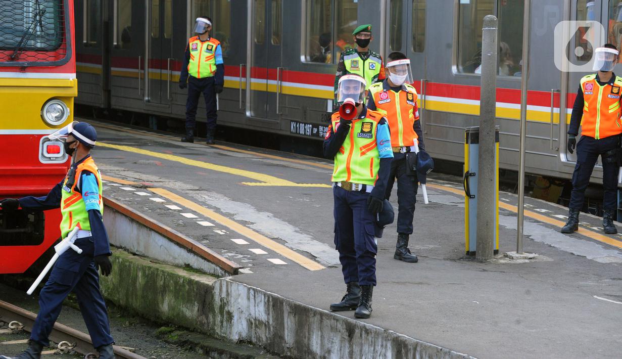 Petugas stasiun memandu penumpang KRL Commuterline di Stasiun Bogor, Jawa Barat, Selasa (9/6/2020) pagi. Puluhan polisi, TNI, Satpol PP, dan petugas stasiun diterjunkan untuk memandu penumpang mengantisipasi antrean panjang seperti kemarin. (merdeka.com/Arie Basuki)