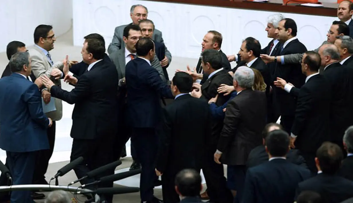 Anggota parlemen partai oposisi (CHP) dan partai berkuasa AK terlibat perkelahian saat pembahasan UU di Ankara, Turki, Kamis (19/2). Kericuhan terjadi setelah perdebatan sengit tentang UU untuk meningkatkan kekuatan polisi. (AFP PHOTO/ADEM ALTAN)