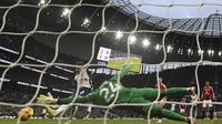 Gelandang Tottenham Hotspur asal Inggris James Maddison (kiri) melepaskan tembakan untuk mencetak gol pembuka melewati kiper Manchester United asal Kamerun Andre Onana (tengah) selama pertandingan sepak bola Liga Primer Inggris antara Tottenham Hotspur dan Manchester United di Stadion Tottenham Hotspur di London, pada 16 Februari 2025.Glyn KIRK / AFP