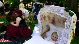 Sejumlah peserta membawa kereta bayi yang berisi boneka saat mengikuti Victorian Picnic selama festival Wave Gotik Treffen (WGT) di Leipzig, Jerman (6/2). Festival ini telah diadakan sejak 1987 dan bermula di Potsdam, Jerman. (AFP Photo/Tobias Schwarz)