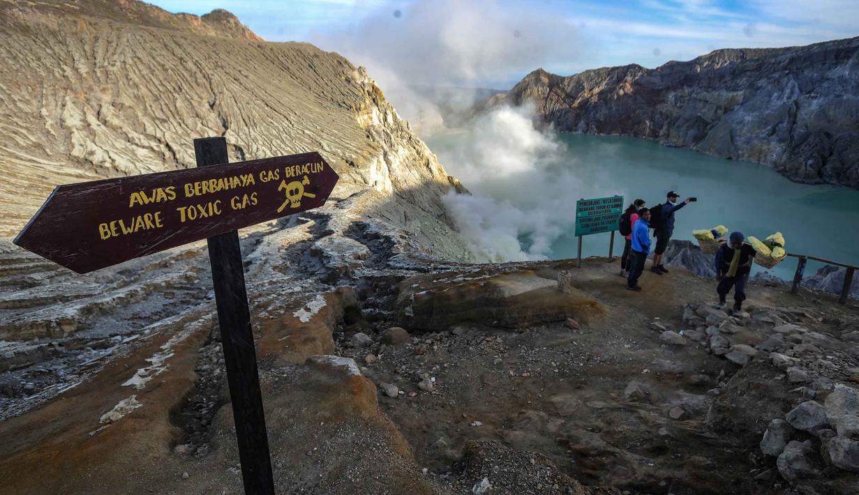 Selain sebagai destinasi wisata, Kawah Ijen juga menjadi lokasi penambangan belerang aktif. Para penambang bekerja secara tradisional tanpa bantuan alat berat. Gas belerang dialirkan melalui pipa besi hingga mengembun menjadi belerang cair dan mengeras menjadi bongkahan berwarna kuning. Bongkahan tersebut kemudian dipikul dengan beban mencapai 75 hingga 90 kilogram melewati jalur terjal menuju Paltuding sejauh sekitar tiga kilometer. Tampak dalam foto, penambang tradisional memikul bongkahan belerang dari dasar kawah Ijen di Banyuwangi, Jawa Timur. (merdeka.com/Arie Basuki)