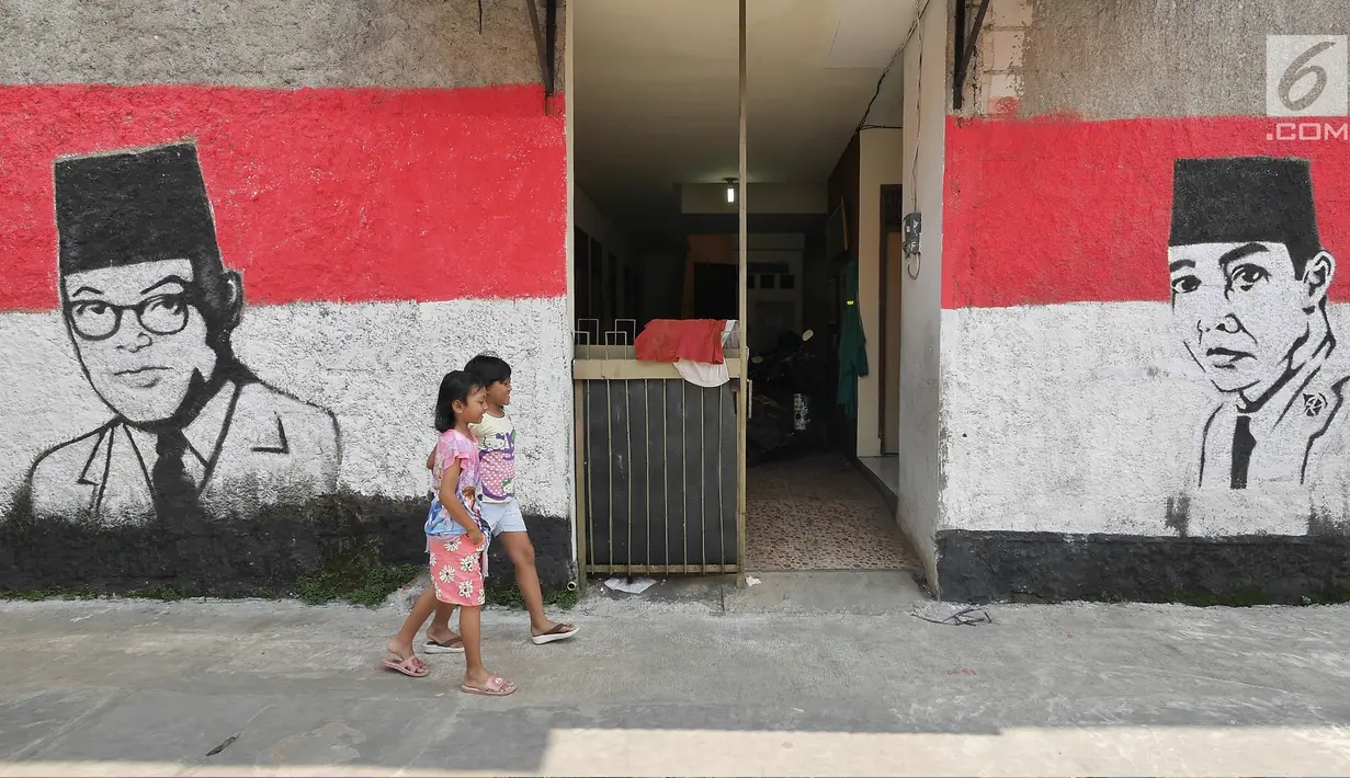 Dua anak melintasi sisi tembok warga yang dindingnya dihiasi lukisan mural Presiden pertama RI, Sukarno di Kampung Pejaten, Jakarta, Senin (30/4). Mural motif warna-warni itu digagas warga untuk memperindah kampung mereka. (Liputan6.com/Herman Zakharia)