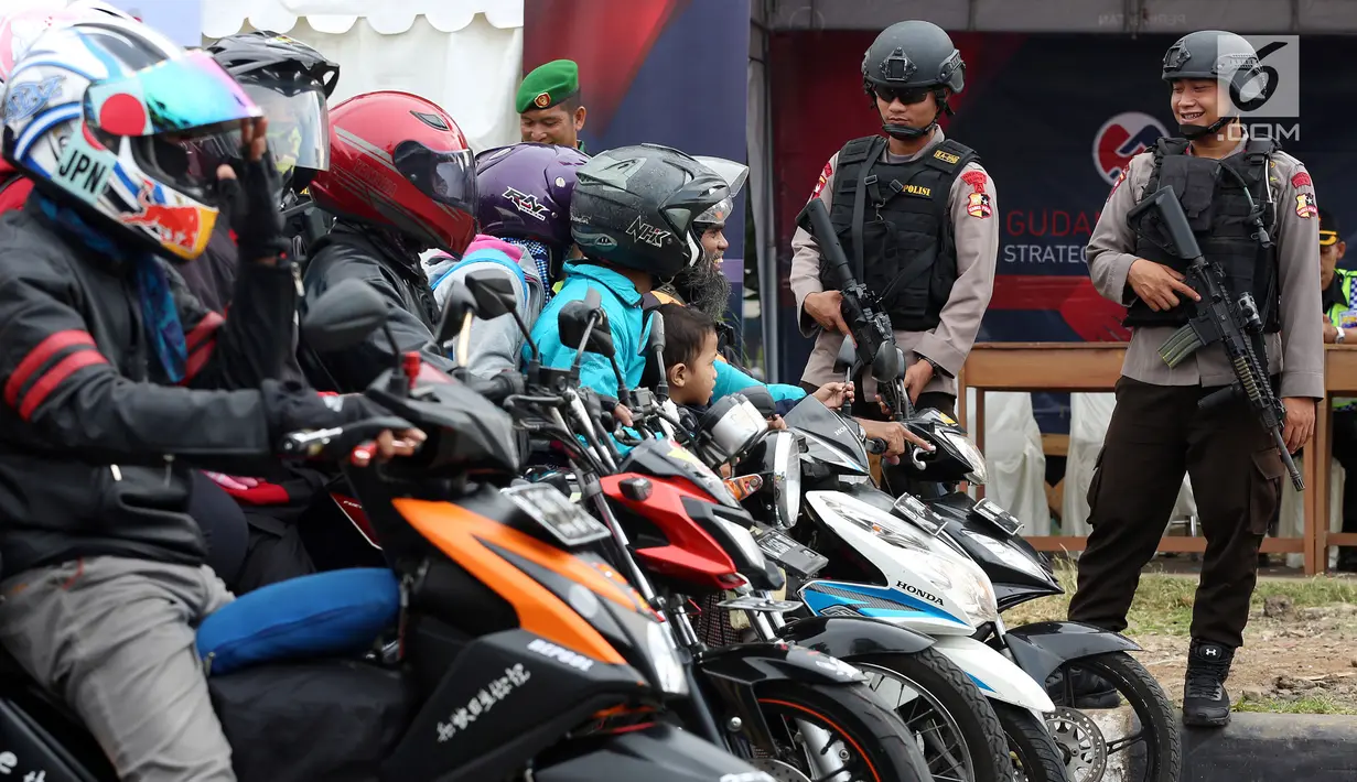 Dua polisi bersenjata laras panjang bersiaga di jalur pantura Jalan Jenderal Ahmad Yani, Bypass, Kota Cirebon, Kamis (22/6). Pasukan bersenjata lengkap diterjunkan untuk mengantisipasi gangguan keamanan selama arus mudik Lebaran (Liputan6.com/Johan Tallo)