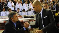 Pelatih asal Portugal Jose Mourinho (kiri) berjabat tangan dengan pelatih Barcelona Josep Guardiola sebelum pertandingan final Piala Spanyol Real Madrid melawan Barcelona di Stadion Mestalla di Valencia pada 20 April 2011. (AFP PHOTO/Lluis GENE)