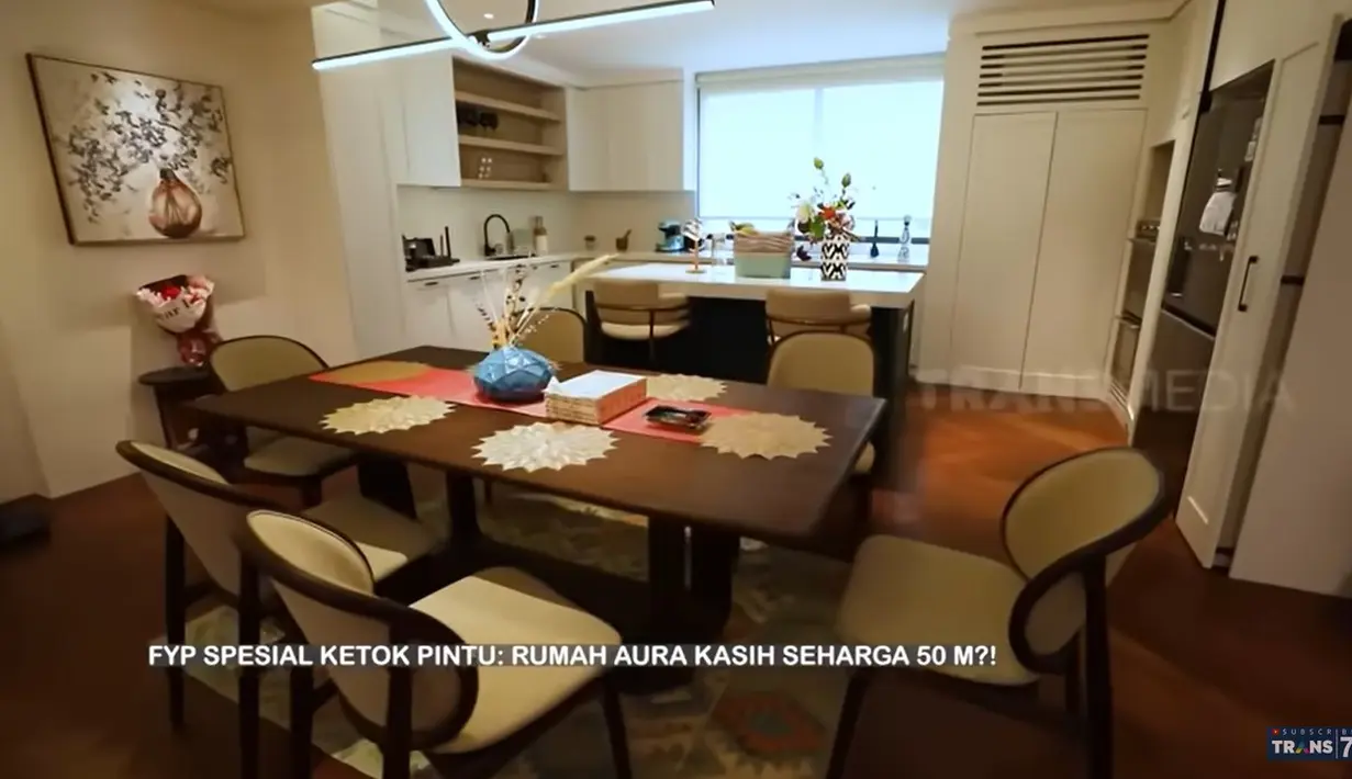 Ruangan tampak luas karena tidak banyak sekat. Meja makan dari kayu dengan beberapa kursi yang digunakan makan bersama keluarga kecilnya. [Youtube/TRANS7 OFFICIAL]