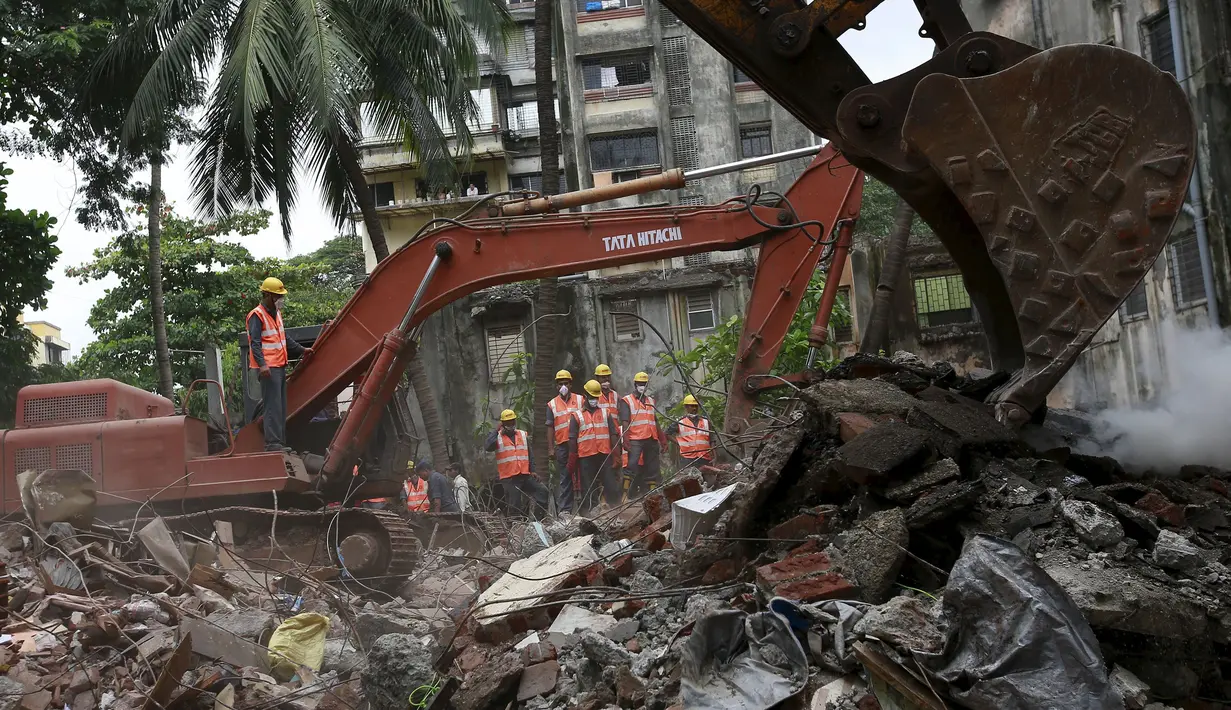 Sebuah alat berat dioperasikan untuk mengangkut puing – puing bangunan yang runtuh di Mumbai, India, Selasa (4/8/2015). Bangunan tersebut runtuh karena kondisinya yang sudah tak layak pakai dan menewaskan 11 orang.(REUTERS/Danish Siddiqui)