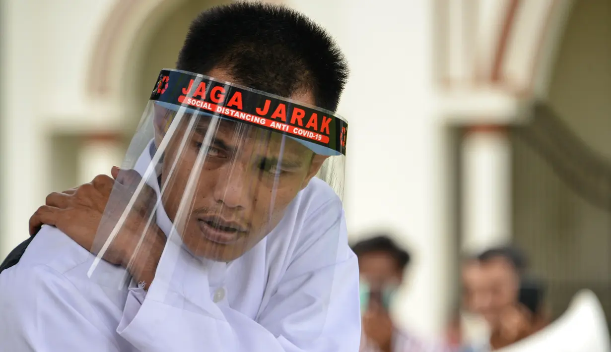 Reaksi salah seorang pasangan terpidana kasus zina saat menjalani hukuman cambuk di Masjid Al Munawarah, Kota Jantho, Aceh Besar, Jumat (4/9/2020). Pasangan terpidana yang terbukti melanggar Syariat Islam dalam kasus zina itu masing masing menjalani sebanyak 100 cambuk. (CHAIDEER MAHYUDDIN/AFP)