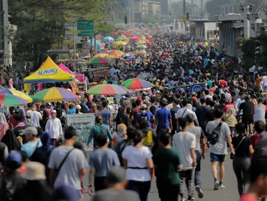 Pedagang kaki lima (PKL) berjualan di jalan saat car free day (CFD) di kawasan Bundaran HI, Jakarta, Minggu (6/10/2019). Kurangnya pengawasan petugas menyebabkan banyak PKL yang berjualan tidak pada tempat yang telah disediakan oleh Pemprov DKI Jakarta. (Liputan6.com/Faizal Fanani)