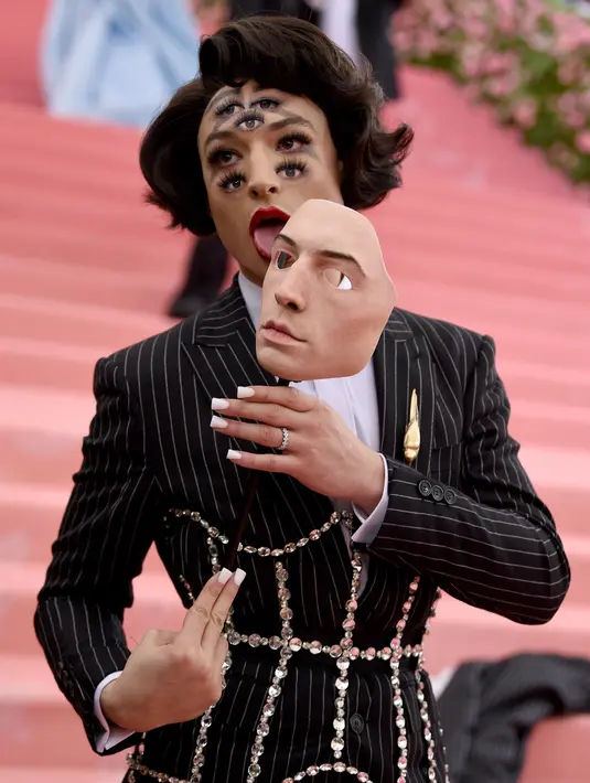 Ezra Miller merias wajahnya dengan banyak mata saat menghadiri Met Gala 2019 bertema Camp: Notes on Fashion di The Metropolitan Museum of Art, New York, Amerika Serikat, Senin (6/5/2019). (Photo by Evan Agostini/Invision/AP)