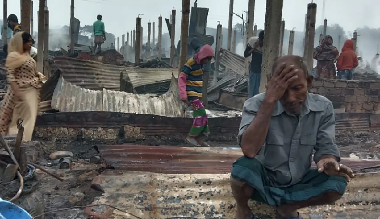 Seorang pengungsi Rohingya yang tampak sedih melihat tempat tinggalnya ludes terbakar saat musibah kebakaran melanda kamp pengungsi Nayapara di Cox's Bazar, Bangladesh (14/1/2021). Tidak ada laporan korban jiwa akibat kebakaran ini. (AP Photo/Mohammed Faisal)
