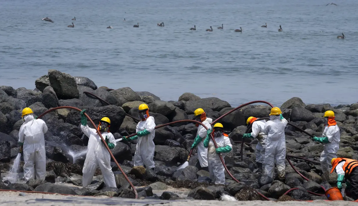 Pekerja melanjutkan kampanye pembersihan minyak di Pantai Pocitos, Ancon, Peru, 15 Februari 2022. Sebulan berlalu, pekerja melanjutkan pembersihan di pantai setelah terkontaminasi tumpahan minyak Repsol. (AP Photo/Martin Mejia)