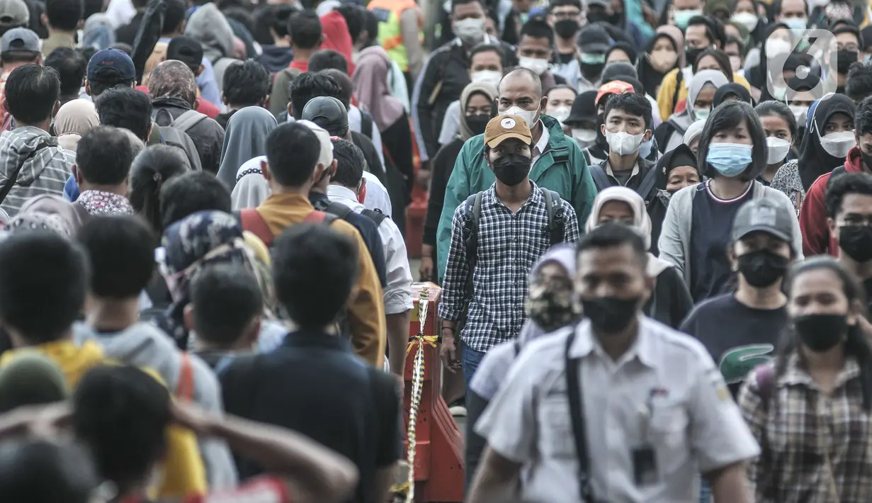 Pekerja melintasi peron saat hendak menaiki kereta Commuter Line (KRL) di Stasiun Manggarai, Jakarta, Senin (27/12/2021). Pemprov DKI resmi menetapkan upah minimum provinsi (UMP) 2022 naik 5,1 persen atau menjadi Rp4.641.854. (merdeka.com/Iqbal S Nugroho)