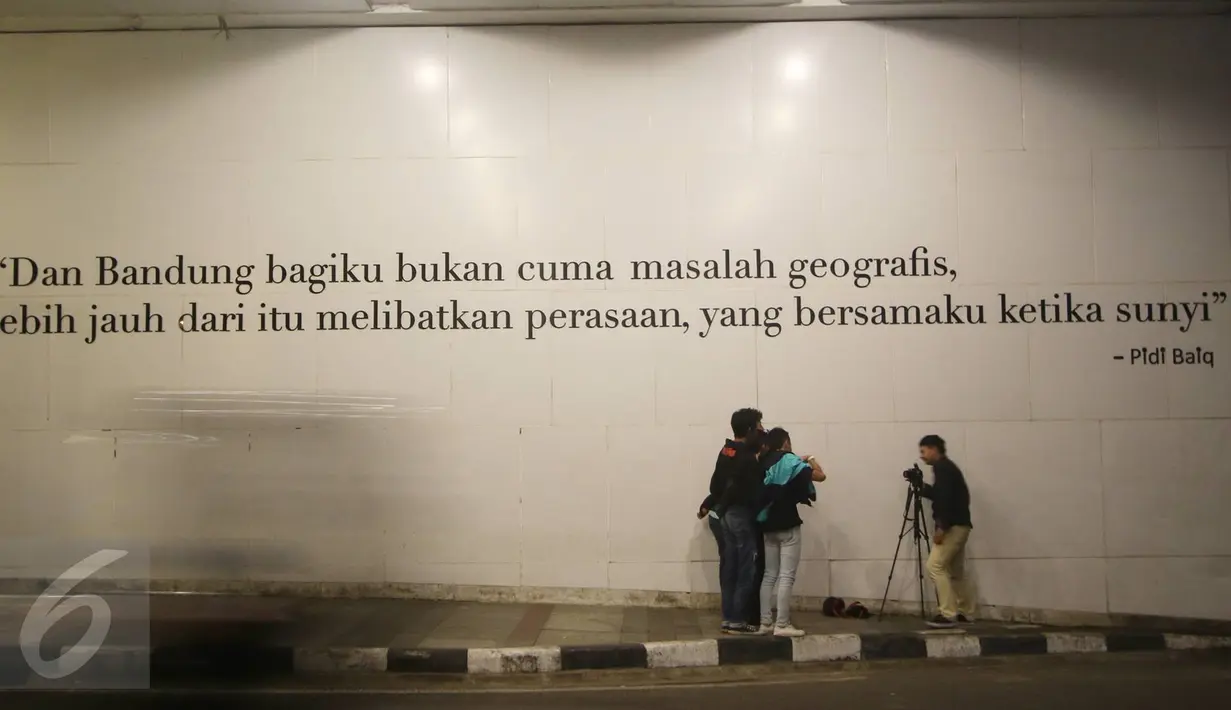 Pengunjung berfoto di depan mural bertema Kota Bandung di Jalan Asia Afrika, Bandung, Jawa Barat, Selasa (5/7). Dua buah mural tersebut menjadi lokasi favorit bagi warga dan wisatawan di Bandung untuk berfoto. (Liputan6.com/Immanuel Antonius)