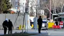 Petugas kepolisian mendekati seorang pria yang tergeletak di tanah, di luar kantor polisi di Gaziantep, Selasa (10/1). Seorang perwira polisi terluka ringan akibat penyerangan yang dilakukan pria tersebut bersama rekannya yang kabur. (AFP PHOTO/STR)