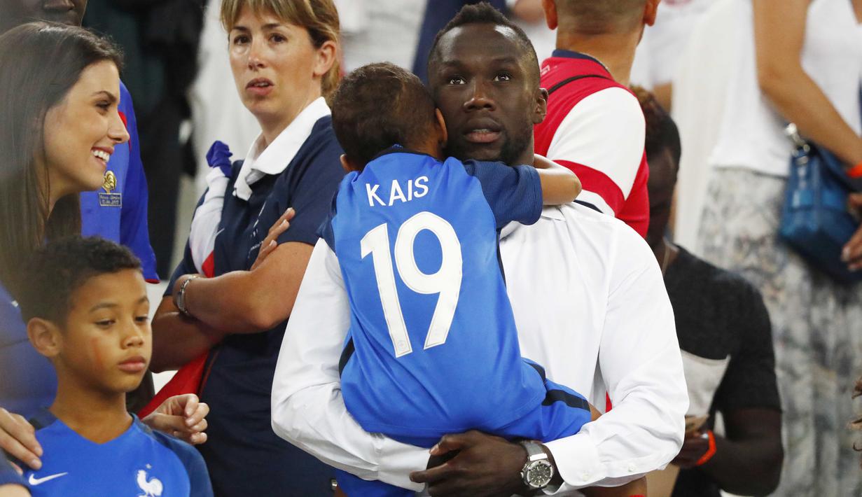 Pemain Prancis, Bacary Sagna menggendong anaknya ditemani istri Ludevin Sagna setalah laga timnya melawan Jerman pada semi-final piala Eropa 2016 di Stade Velodrome, Marseille (7/7/2016). (REUTERS/Christian Hartmann)