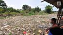 Warga melihat Kali Pisang Batu yang dipenuhi sampah, Tarumajaya, Bekasi, Jawa Barat, Rabu (9/1). Warga tetap beraktivitas sehari-hari meski bau tak sedap menghantui mereka akibat tumpukan sampah di Kali Pisang Batu. (Merdeka.com/Iqbal S. Nugroho)