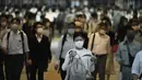 Komuter yang mengenakan masker berjalan di lorong selama jam sibuk di Stasiun Shinagawa, Tokyo, Jumat (1/10/2021). Pemerintah Jepang mencabut keadaan darurat di semua wilayah pada 1 Oktober 2021. (AP Photo/Eugene Hoshiko)