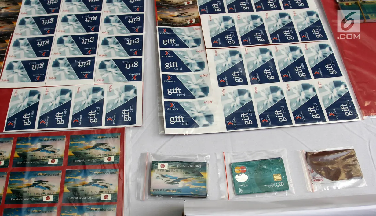Barang bukti tindak pidana pemalsuan atau pencurian data elektronik (skimming) di Polda Metro Jaya, Jakarta, Senin (19/3). Polisi menyita 196 kartu ATM, dua alat deep skimmer, laptop, paspor, dan uang tunai Rp 50 juta. (Liputan6.com/Arya Manggala)