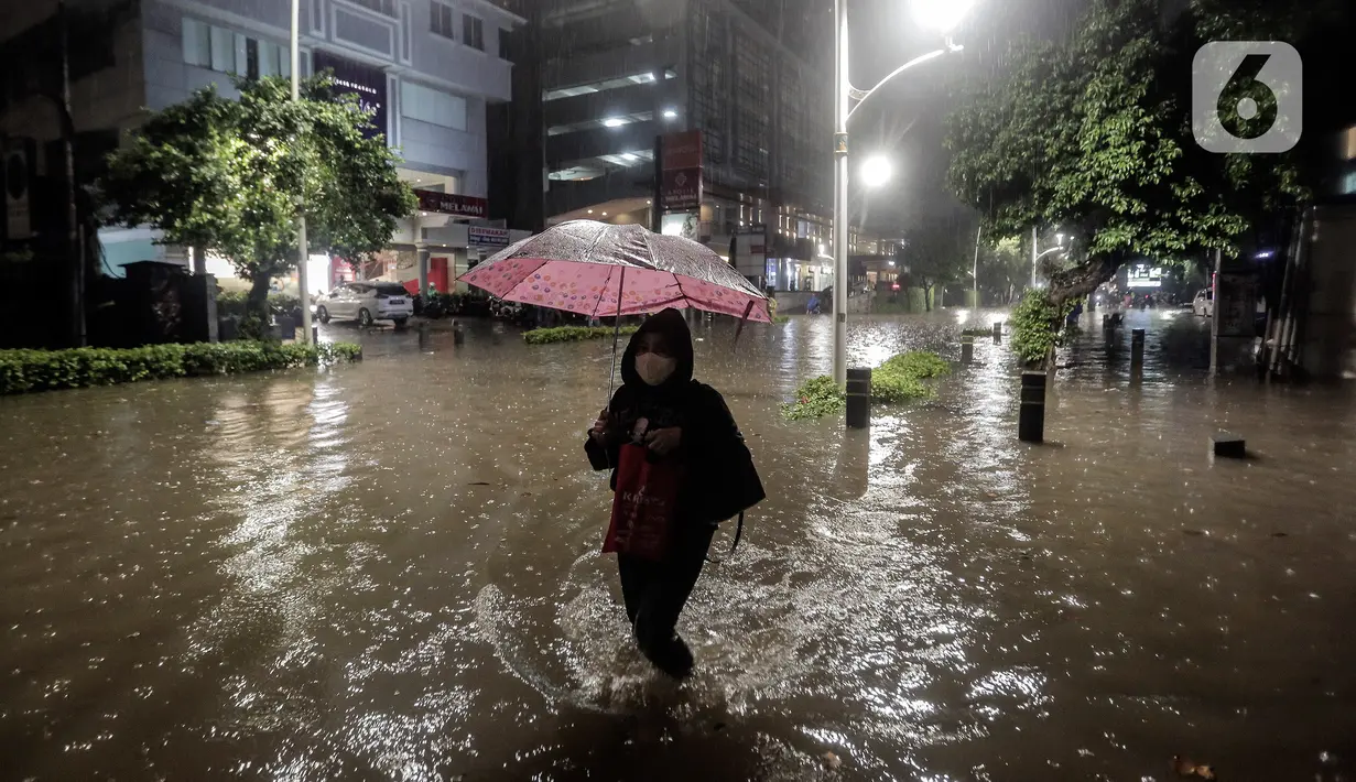 Warga mengunakan payung melintasi banjir di Jalan Kemang Raya, Jakarta Selatan, Selasa (4/10/2022). Hujan yang mengguyur wilayah Ibu Kota Jakarta mengakibatkan banjir menggenangi kawasan Kemang, Jakarta. (Liputan6.com/Johan Tallo)