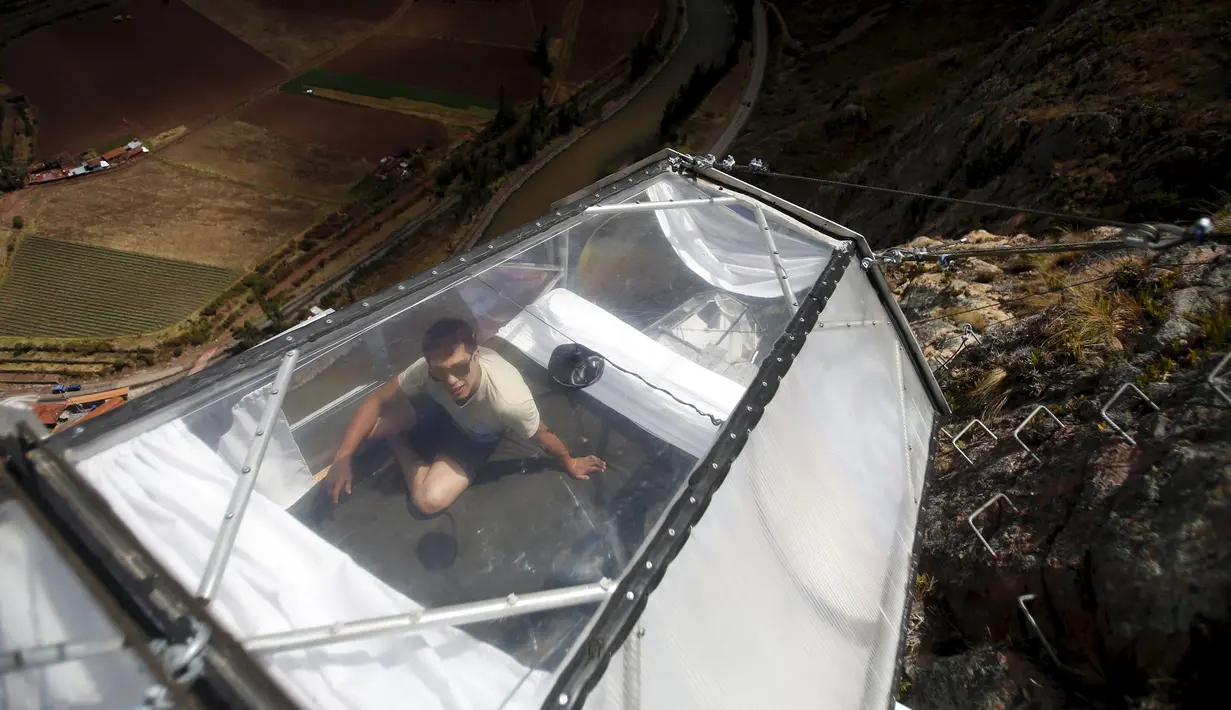 Seorang pemandu resort membersihkan kapsul tidur di Skylodge Adventure Suites di Lembah Suci di Cuzco, Peru, 14 Agustus 2015. Hotel yang tergantung dengan ketinggian 400 meter ini memiliki tarif sekitar Rp 4 juta per malam. (REUTERS/Pilar Olivares)