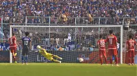 Kiper Arema FC, Kurniawan Kartika Ajie, saat menghalau tendangan penalti striker Persija Jakarta, Marko Simic, dalam laga pekan ke-28 Shopee Liga 1 2019 di Stadion Kanjuruhan, Malang, Sabtu (23/11/2019) sore WIB. (Bola.com/Iwan Setiawan)