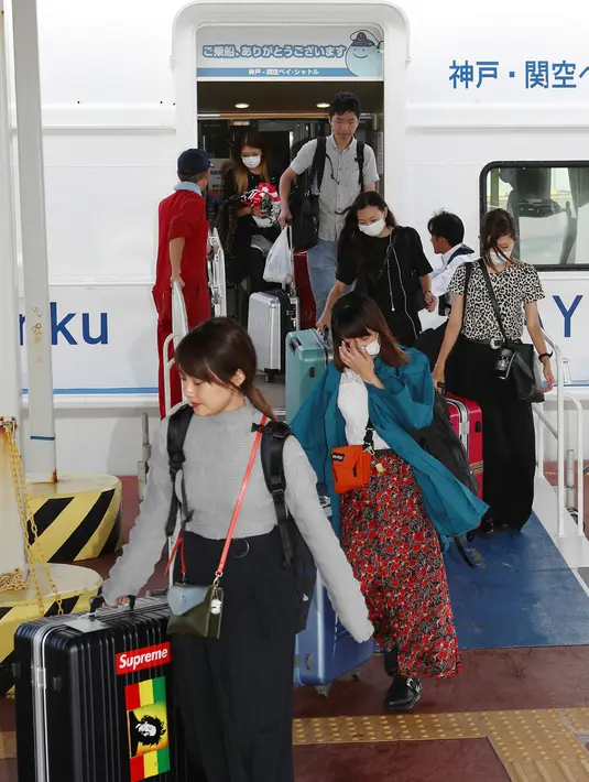 Penumpang yang terdampar semalam di Bandara Internasional Kansai karena topan Jebi tiba dengan menggunakan kapal di pelabuhan Kobe, Rabu (5/9). Terjangan topan Jebi yang dahsyat membuat Bandara Kansai di Osaka, Jepang ditutup sementara. (AFP/JIJI PRESS)