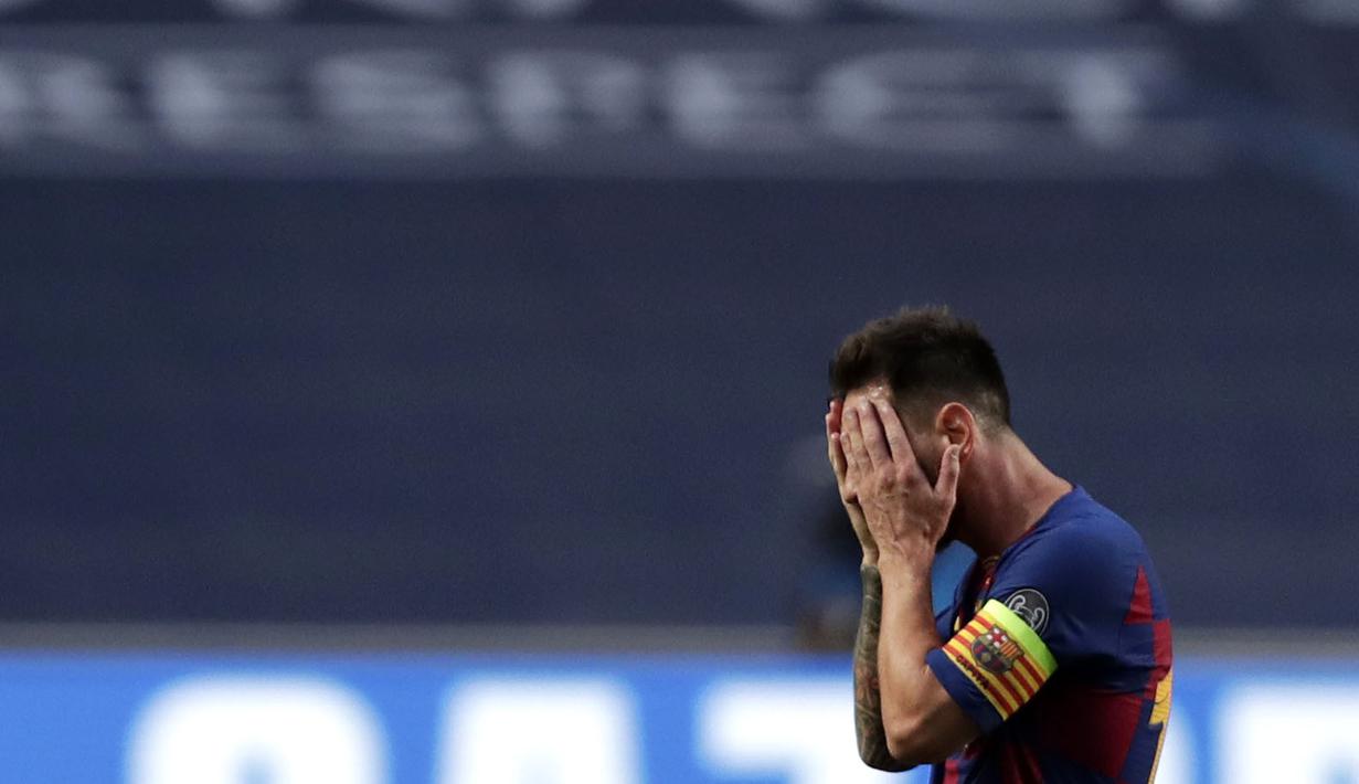 Striker Barcelona, Lionel Messi, menutup wajahnya usai ditaklukkan Bayern Munchen pada laga perempat final Liga Champions di Estadio da Luz, Sabtu (15/8/2020). Barcelona takluk 2-8 dari Bayern Munchen. (Manu Fernandez/POOL/AFP)