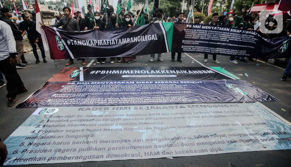 Sejumlah massa yang tergabung dalam Himpunan Mahasiswa Islam (HMI) membentangkan spanduk besar bertuliskan tuntutan saat menggelar aksi di depan Patung Kuda, Jakarta, Senin (29/8/2022). Mereka menolak rencana pemerintah untuk menaikkan harga BBM bersubsidi karena akan mengorbankan kondisi ekonomi rakyat, terutama masyarakat kelas menengah ke bawah dan pelaku Usaha Mikro Kecil Menengah (UMKM), yang belum sepenuhnya pulih akibat terpaan pandemi COVID-19. (Liputan6.com/Faizal Fanani)