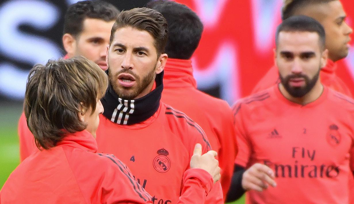 Bek Real Madrid, Sergio Ramos, berbincang dengan Luka Modric, saat latihan jelang laga Liga Champions 2019 di Johan Cruijff Arena, Selasa (12/2). Real Madrid akan berhadapan dengan Ajax Amsterdam. (AFP/Emmanuel Dunand)