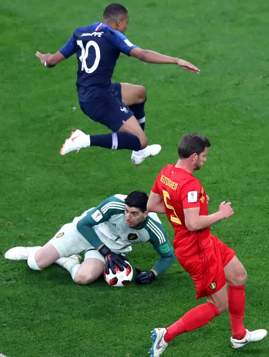 Pemain timnas Prancis, Kylian Mbappe melompati kiper Belgia, Thibaut Courtois pada babak semifinal di Stadion St. Petersburg, Selasa (10/7). Prancis meraih tiket final Piala Dunia 2018 setelah mengalahkan Belgia 1-0. (AP/Thanassis Stavrakis)