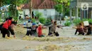 Petugas berusaha mengevakuasi warga saat banjir bandang  di Kabupaten Bone Bolango, Gorontalo (11/6/2020). Data sementara yang diterima dari BPBD Kabupaten Bone Bolango sekitar 1.078 kepala keluarga serta 5.407 jiwa terdampak banjir bandang. (Liputan.com/Arfandi Ibrahim)