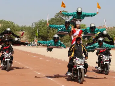 Para calon polisi India saat tampil beratraksi ekstrem di atas sepeda motor selama mengikuti parade di Pusat Pelatihan Polisi Rajasthan di Jodhpur, India, Jumat (24/4/2015).(AFP FOTO)