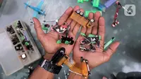Petugas UPS Badan Air DLH Provinsi DKI Jakarta, Bang Timan menunjukkan miniatur kendaraan yang terbuat dari limbah korek api di Jakarta, Kamis (3/8/2023). Sisi lain Bang Timan adalah beliau dikenal dengan kemampuannya mengubah limbah korek api untuk dijadikan kerajinan tangan yang menarik. (Liputan6.com/Johan Tallo)