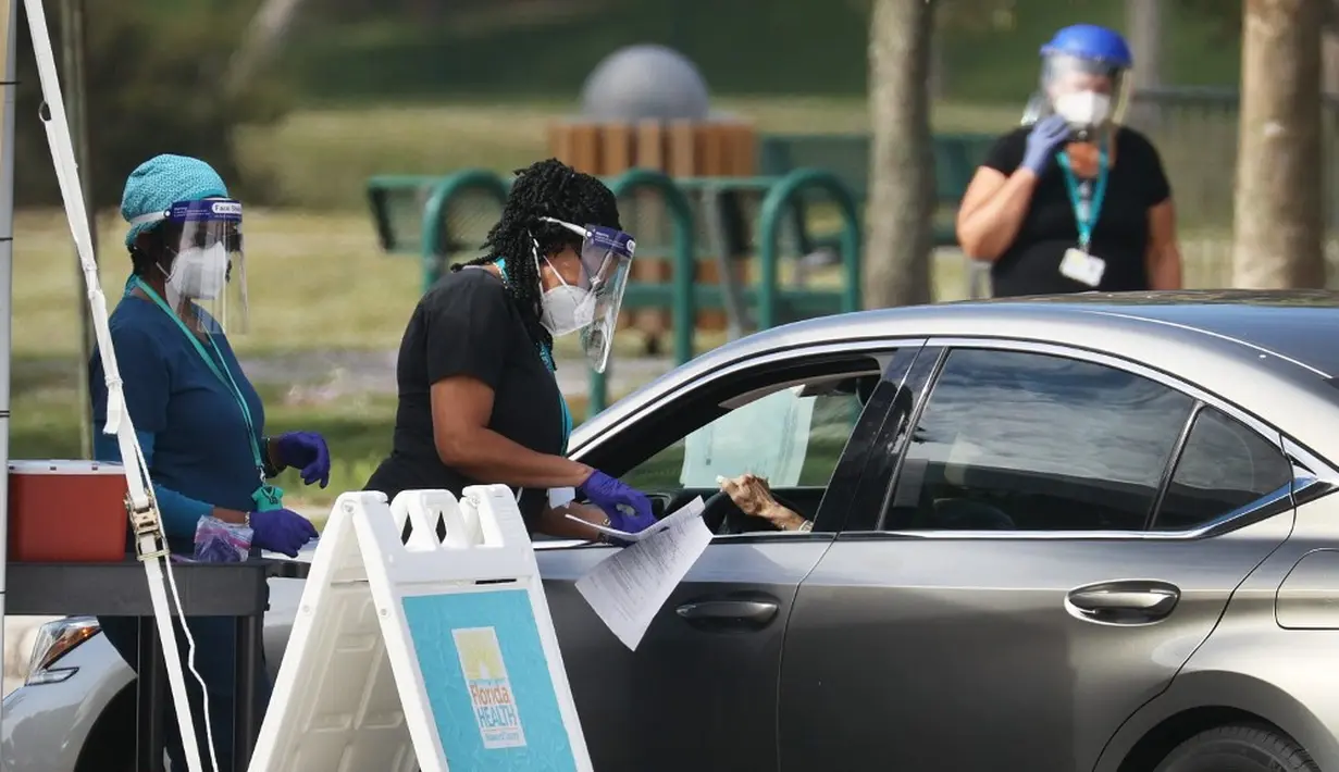 Petugas kesehatan bersiap untuk memberikan vaksin virus corona COVID-19 secara drive-thru di Vista View Park, Davie, Florida, Amerika Serikat, 4 Januari 2021. Lokasi vaksinasi COVID-19 drive-thru tersebut disiapkan untuk penduduk Broward yang berusia 65 tahun ke atas. (Joe Raedle/Getty Images/AFP)