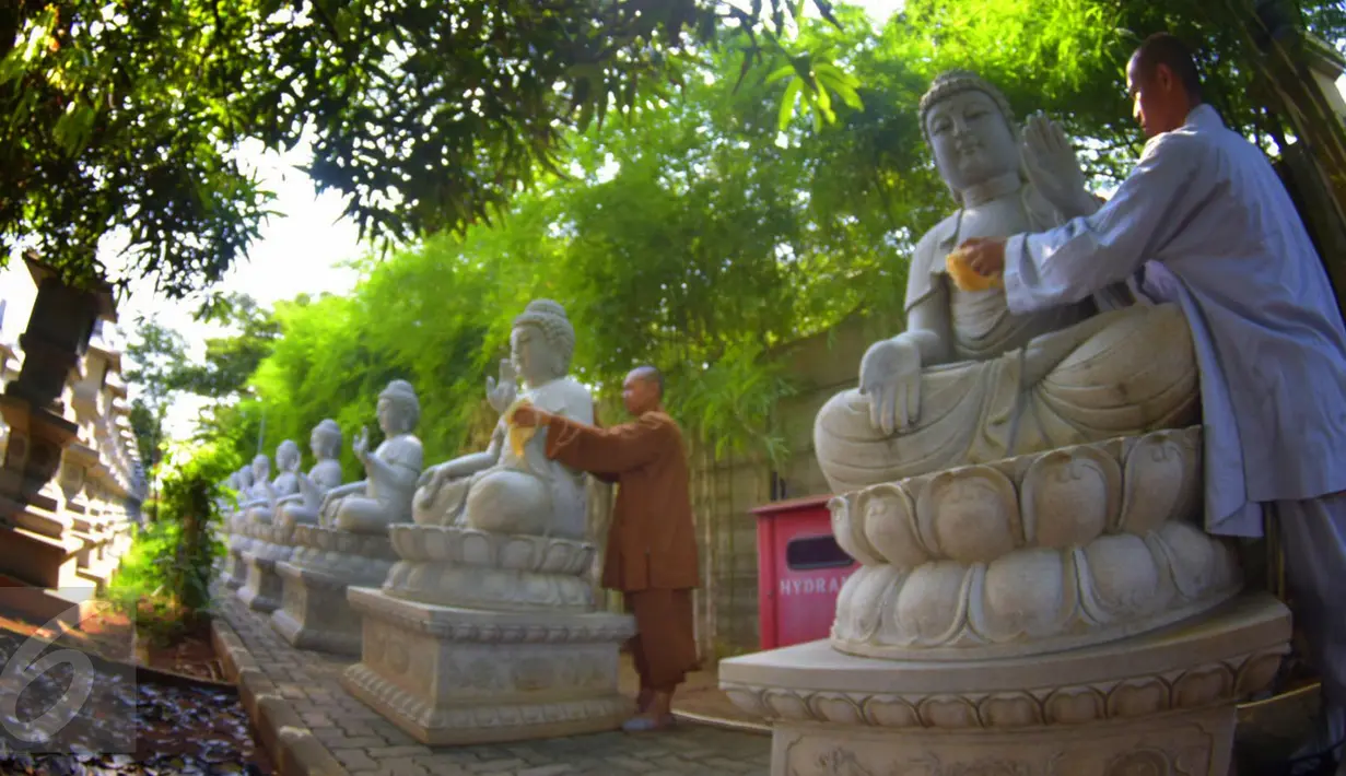 Dua orang bhiksu membersihkan patung di  Vihara Mahavira Graha Semarang , Sabtu ( 21/5/2016). Kegiatan ini dilakukan untuk menyambut hari Waisak besok. (Gholib)