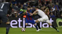 Striker Barcelona, Lionel Messi, berusaha melewati bek Sevilla, Clement Lenglet. Barcelona mendominasi pertandingan dengan penguasaan bola hingga 55 persen sementara Sevilla 45 persen. (AFP/Lluis Gene).