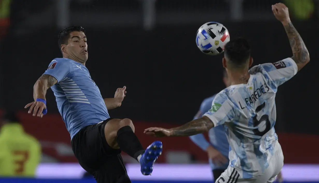Penyerang Uruguay Luis Suarez berebut bola dengan gelandang Argentina Leandro Paredes pada laga Kualifikasi Piala Dunia 2022 Zona Amerika Selatan di Monumental stadium, Senin (11/10/2021) pagi WIB. Argentina melibas Uruguay dengan skor 3-0. (Juan Mabromata / AFP)