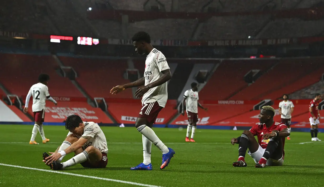 Pemain Manchester United Paul Pogba (kanan) melanggar pemain Arsenal Hector Bellerin sehingga mengasilkan tendangan penalti pada pertandingan Liga Premier Inggris di Stadion Old Trafford, Manchester, Inggris, Minggu (1/11/2020). Arsenal menang 2-0. (Paul Ellis/Pool via AP)